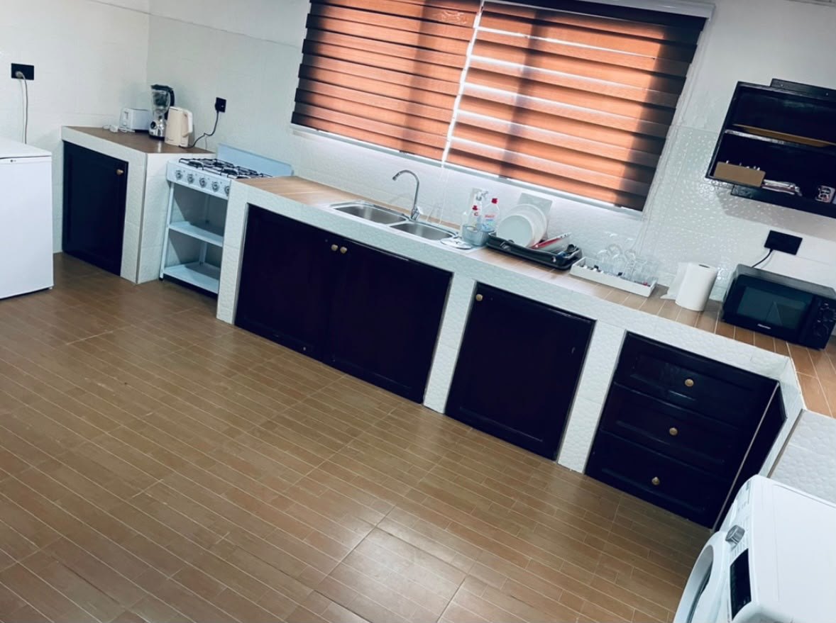 Furnished kitchen with gas cooker, sink, microwave and washing machine